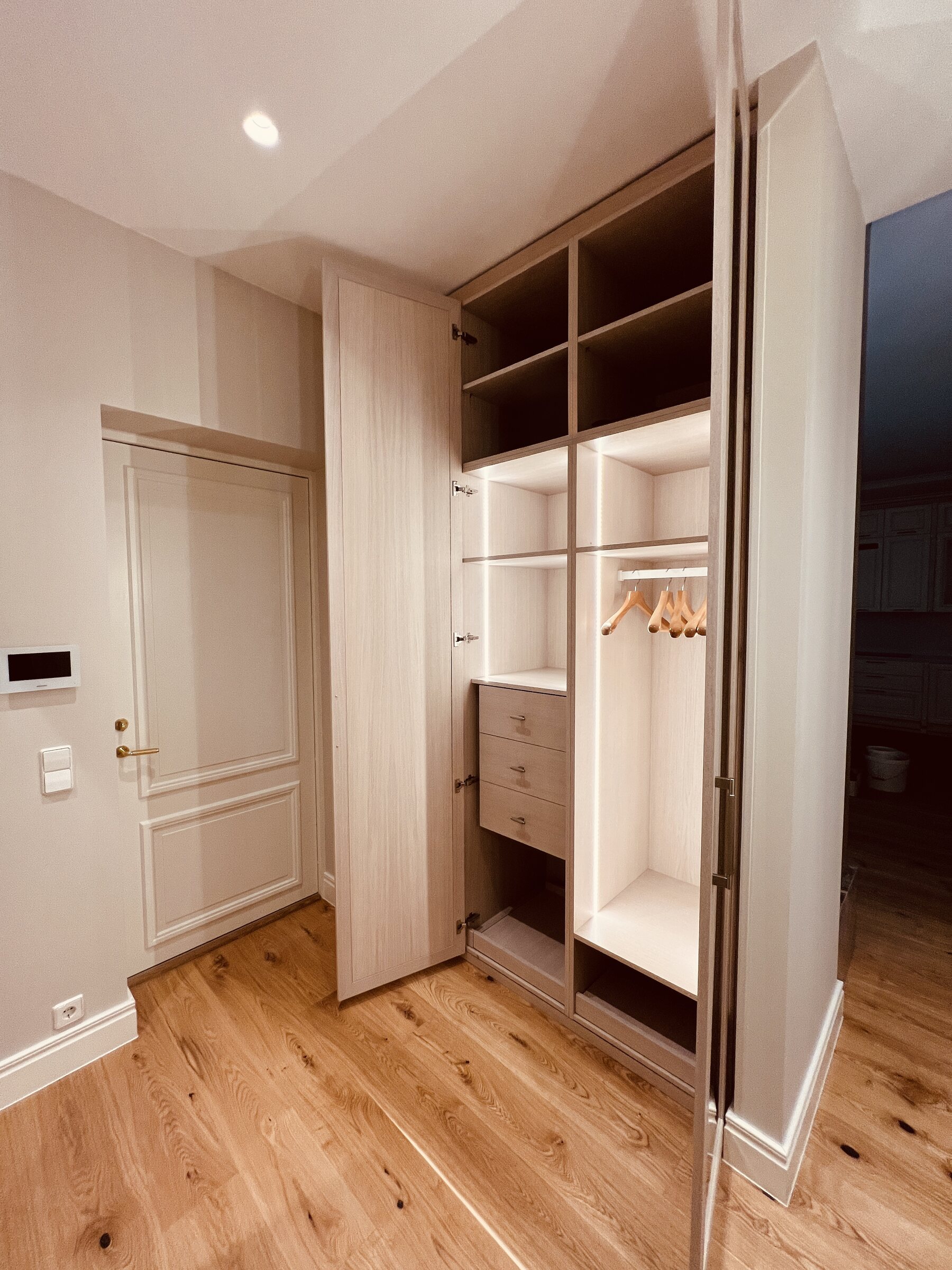 Illuminated fitted wardrobe with open internal storage