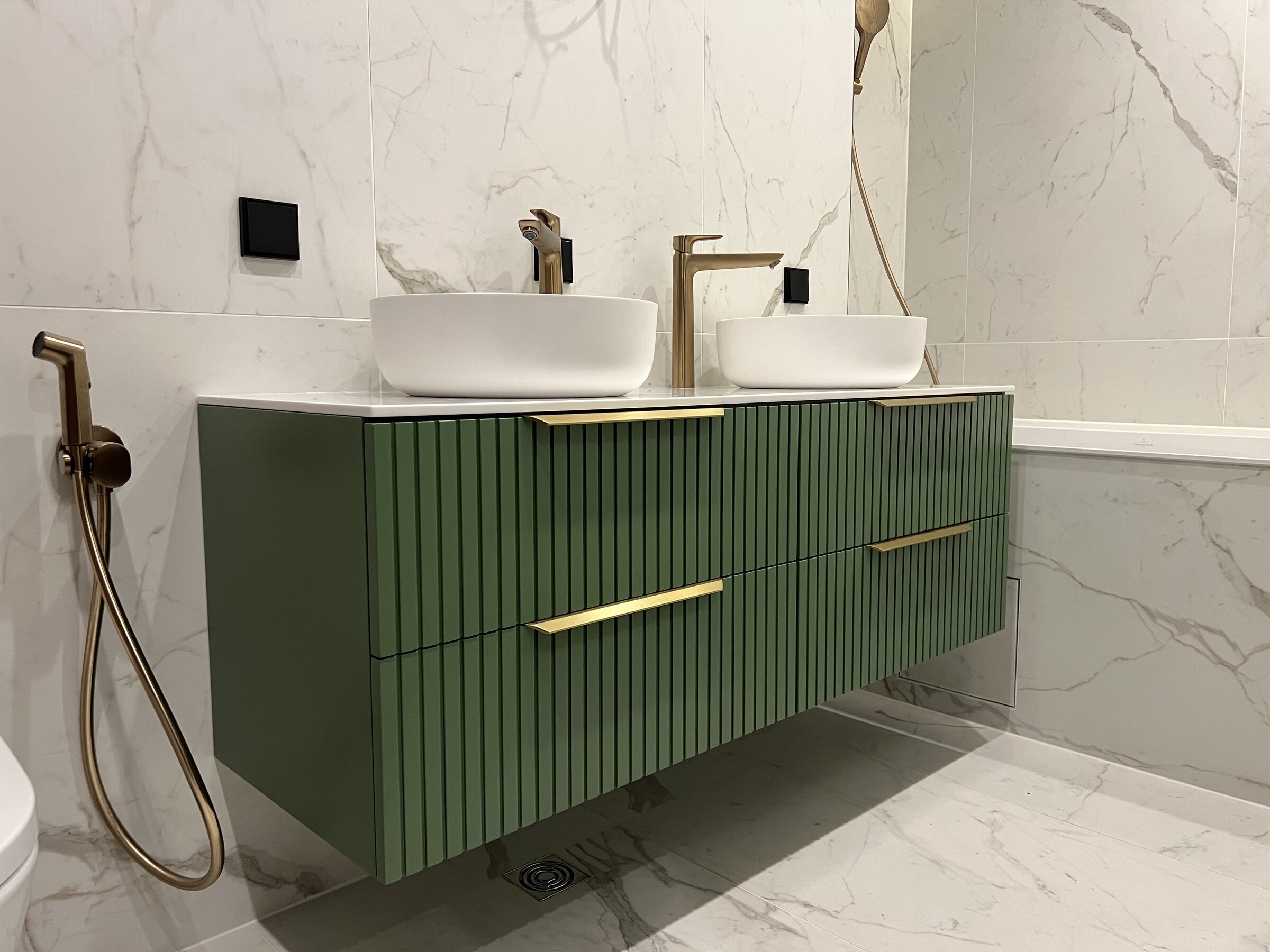 Fluted green bathroom vanity with brass details