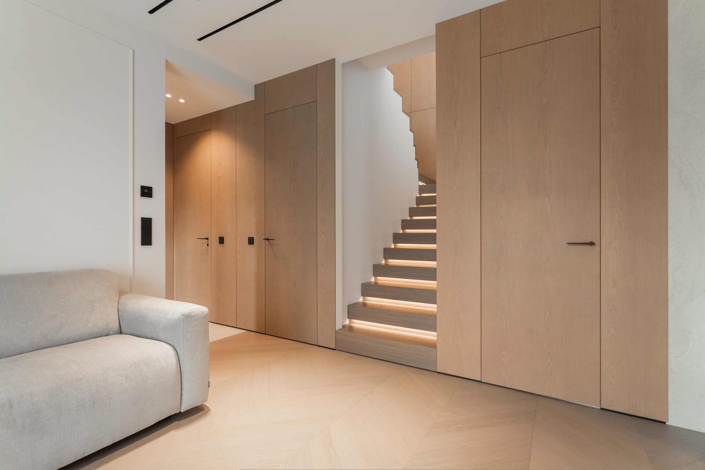 Oak panelling, integrated doors and illuminated staircase in an Estonian private residence